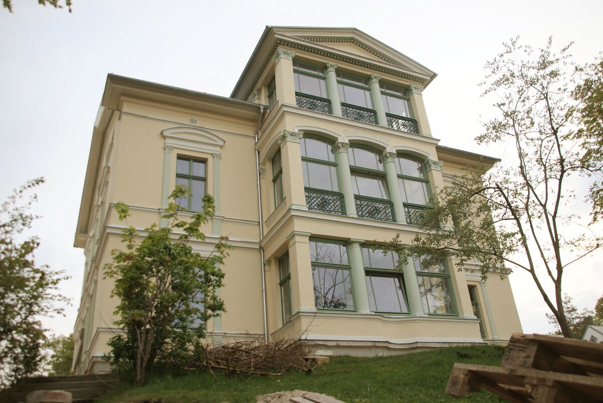Sanierte Fassade einer historischen Villa mit restaurierten Stuckelementen und grünen Fenstern, Fassadenarbeiten Sachsen-Anhalt